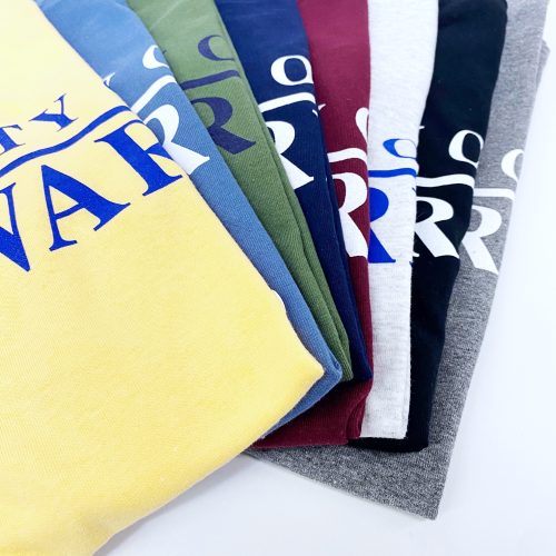 Detail photo of assorted darker colors of University of Delaware Skittles T-shirts